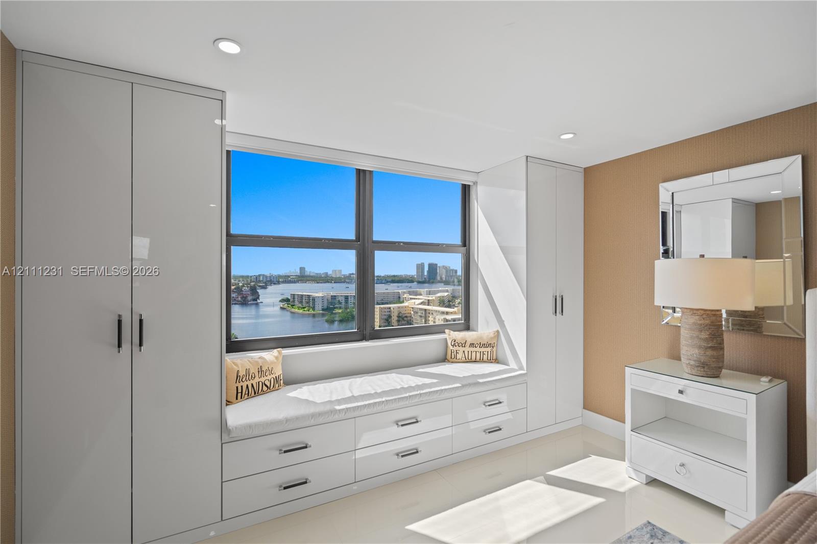 Built-in high-gloss cabinetry, floor-to-ceiling wardrobe storage, integrated window seat with drawer storage, and recessed lighting
