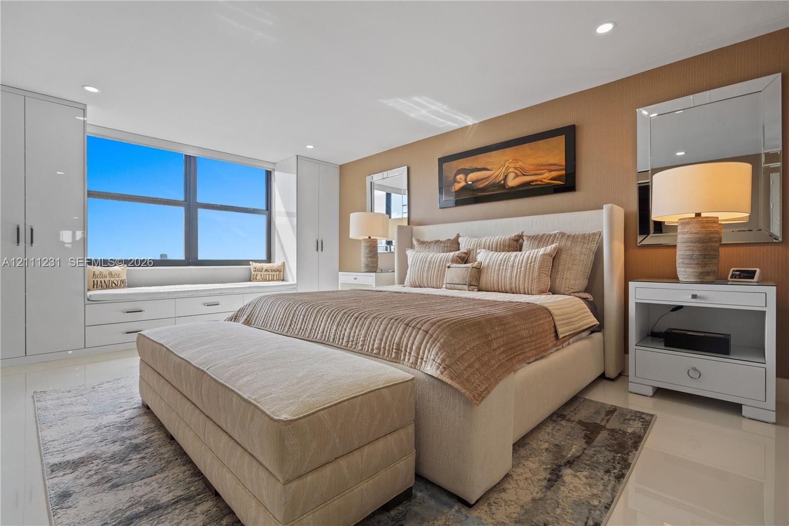 Spacious interior featuring high-gloss flooring, large picture window with built-in cabinetry, and full-height wardrobe storage