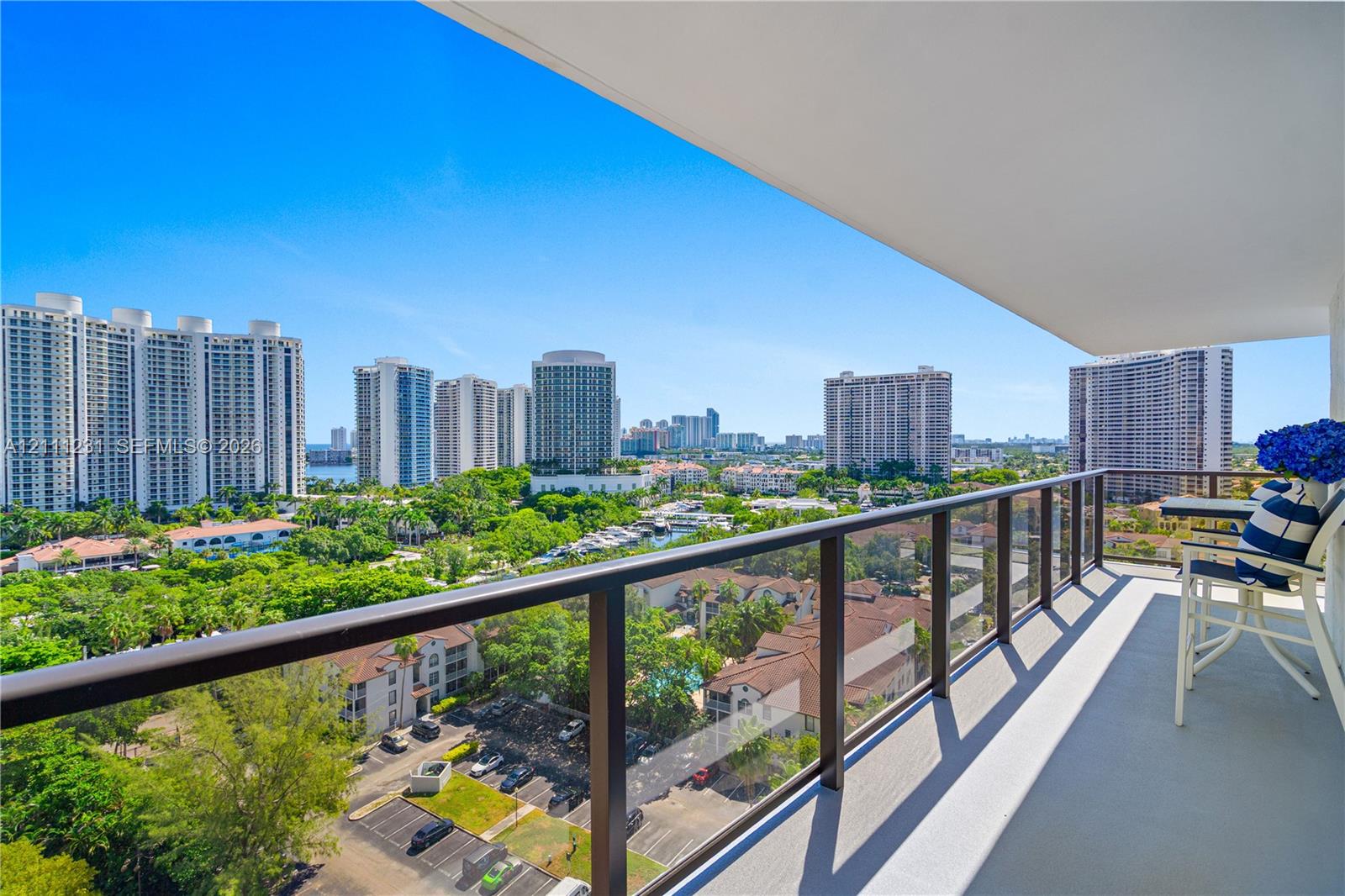 Covered balcony featuring a glass-panel railing and concrete flooring