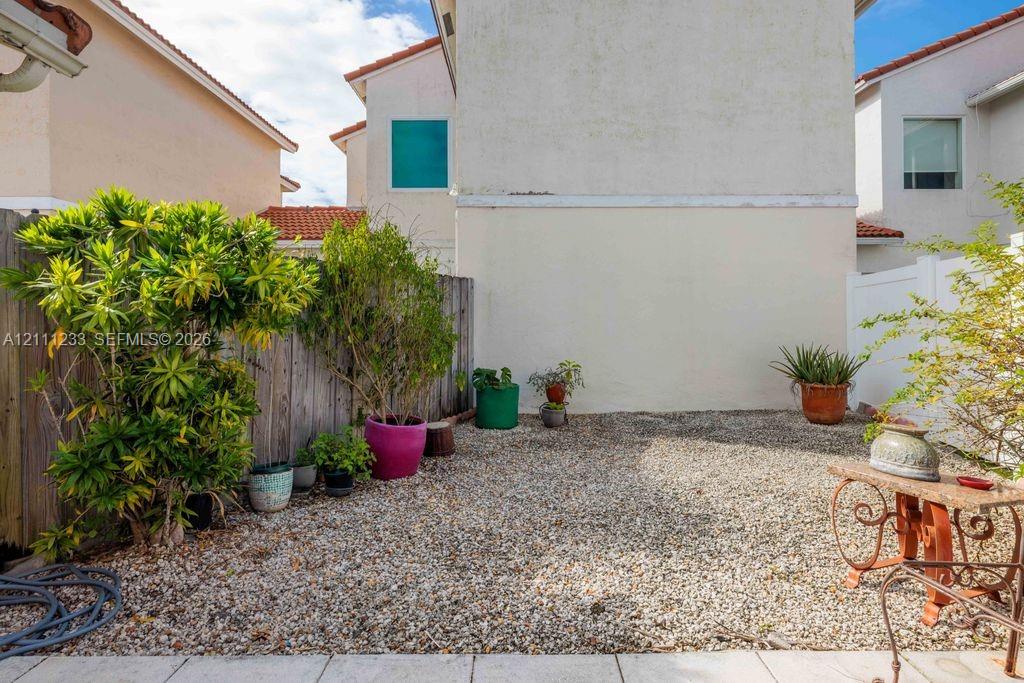 Enclosed patio area featuring crushed stone ground cover and perimeter wood fencing