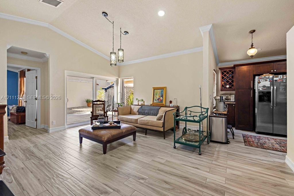 Vaulted ceilings with recessed lighting, wood-finish tile flooring, sliding glass doors, and dark wood cabinetry with built-in wine storage Vaulted ceilings with recessed lighting, wood-finish tile flooring, sliding glass doors, and dark wood cabinetry with built-in wine storage