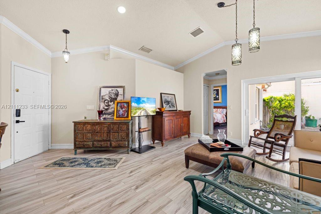 Vaulted ceilings featuring recessed lighting and decorative pendant fixtures, complemented by wood-finish flooring and sliding glass doors Vaulted ceilings featuring recessed lighting and decorative pendant fixtures, complemented by wood-finish flooring and sliding glass doors