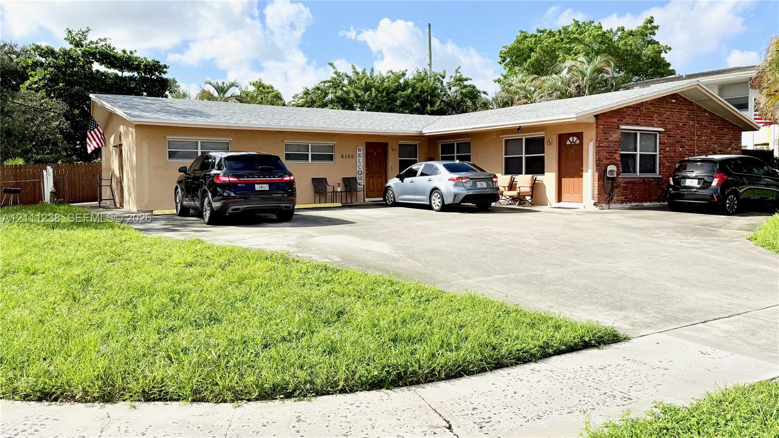 Single-story exterior featuring a stucco and brick facade, hip roof, concrete driveway, and dual entry doors