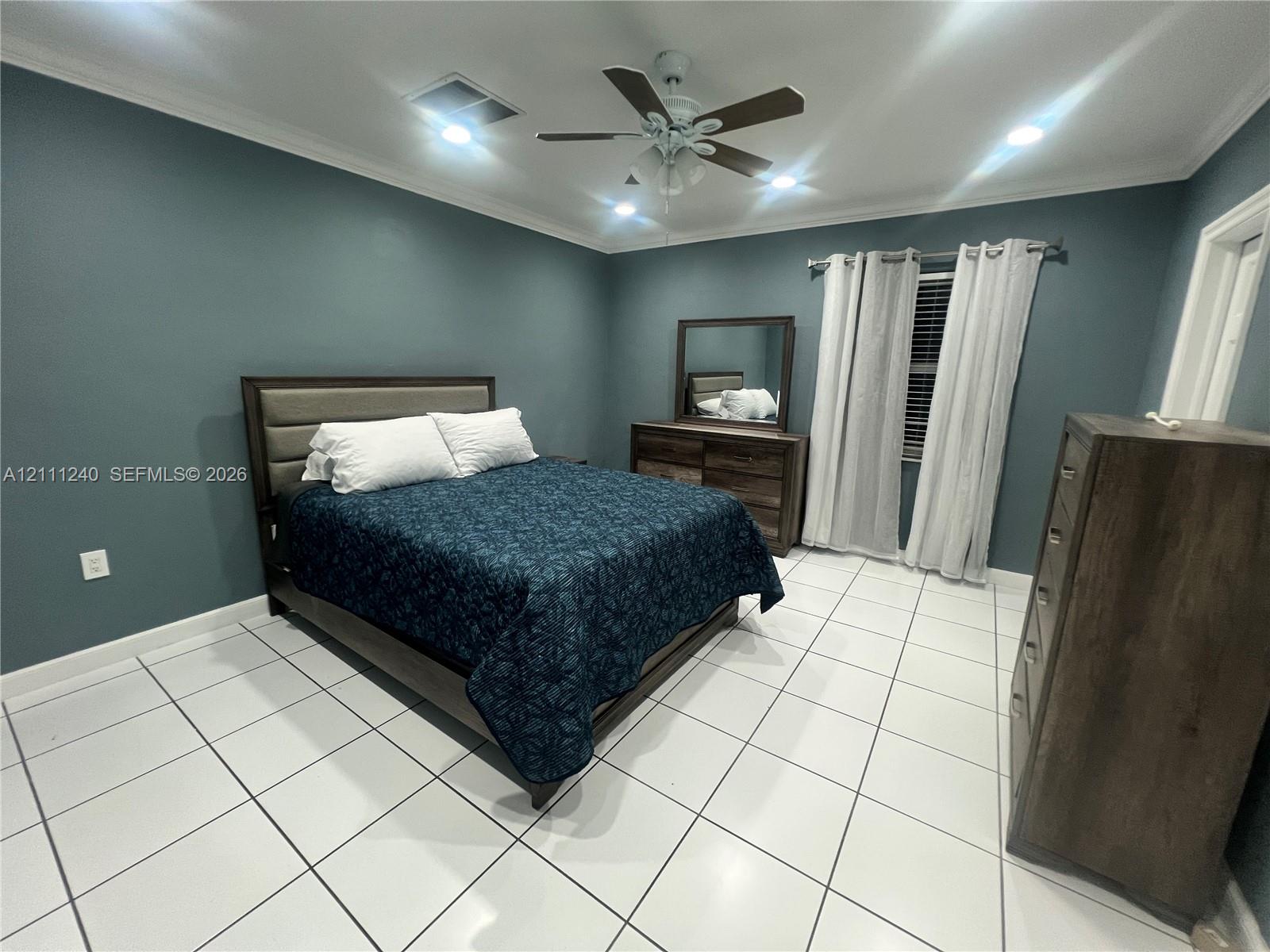 Room featuring large-format tile flooring, crown molding, recessed lighting, and a ceiling fan