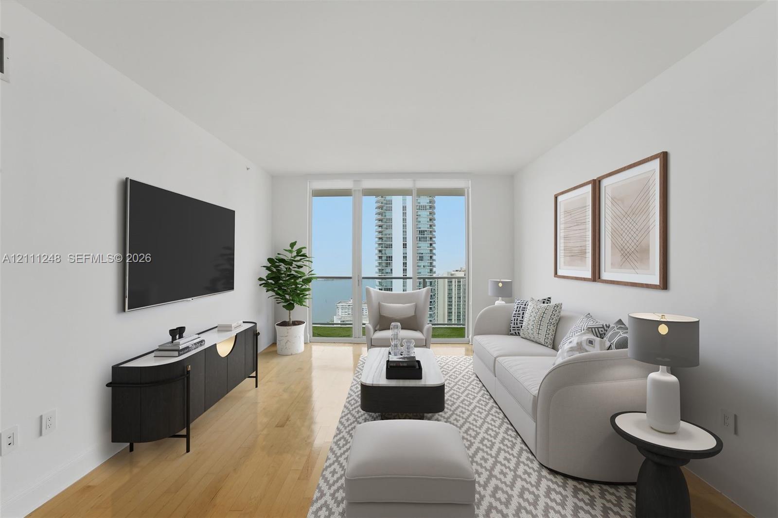 Living area featuring wood-finish flooring, floor-to-ceiling glass panel doors, and access to a private balcony Living area featuring wood-finish flooring, floor-to-ceiling glass panel doors, and access to a private balcony