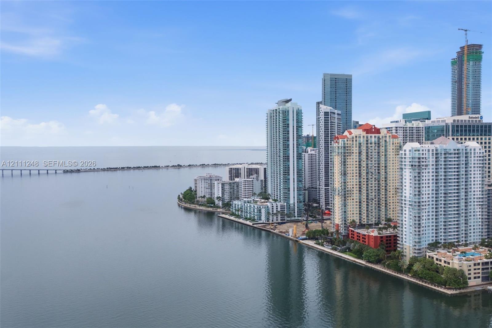 Panoramic urban skyline featuring high-rise architecture, direct waterfront positioning, and an expansive bay expanse
