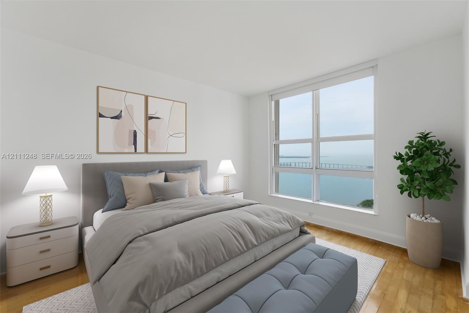 Floor-to-ceiling windows featuring water and bridge scenery, wood-finish flooring, and neutral wall color