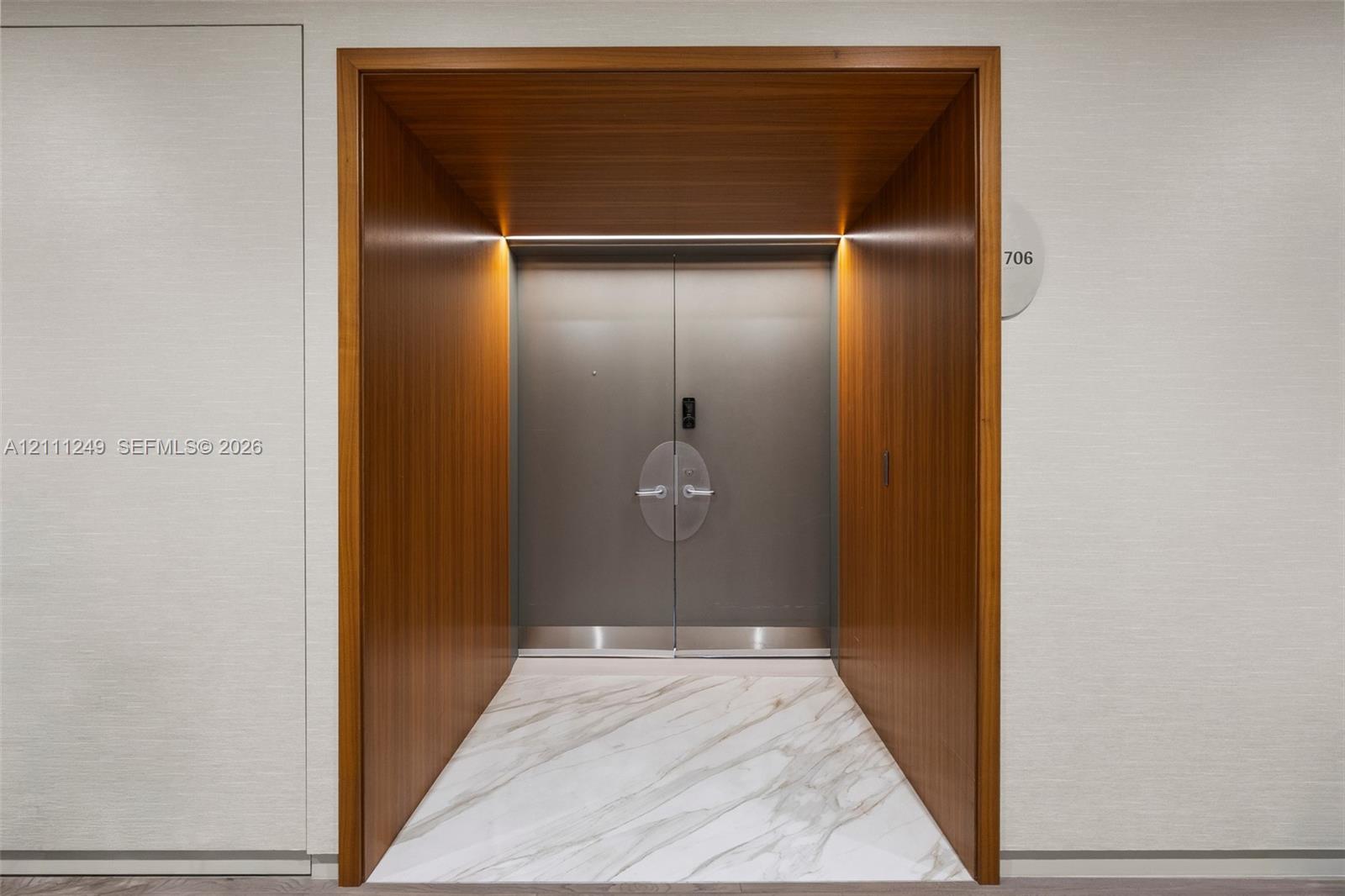 Stone tile flooring featuring geometric inlay, recessed lighting, and a white interior door with matte black hardware Stone tile flooring featuring geometric inlay, recessed lighting, and a white interior door with matte black hardware