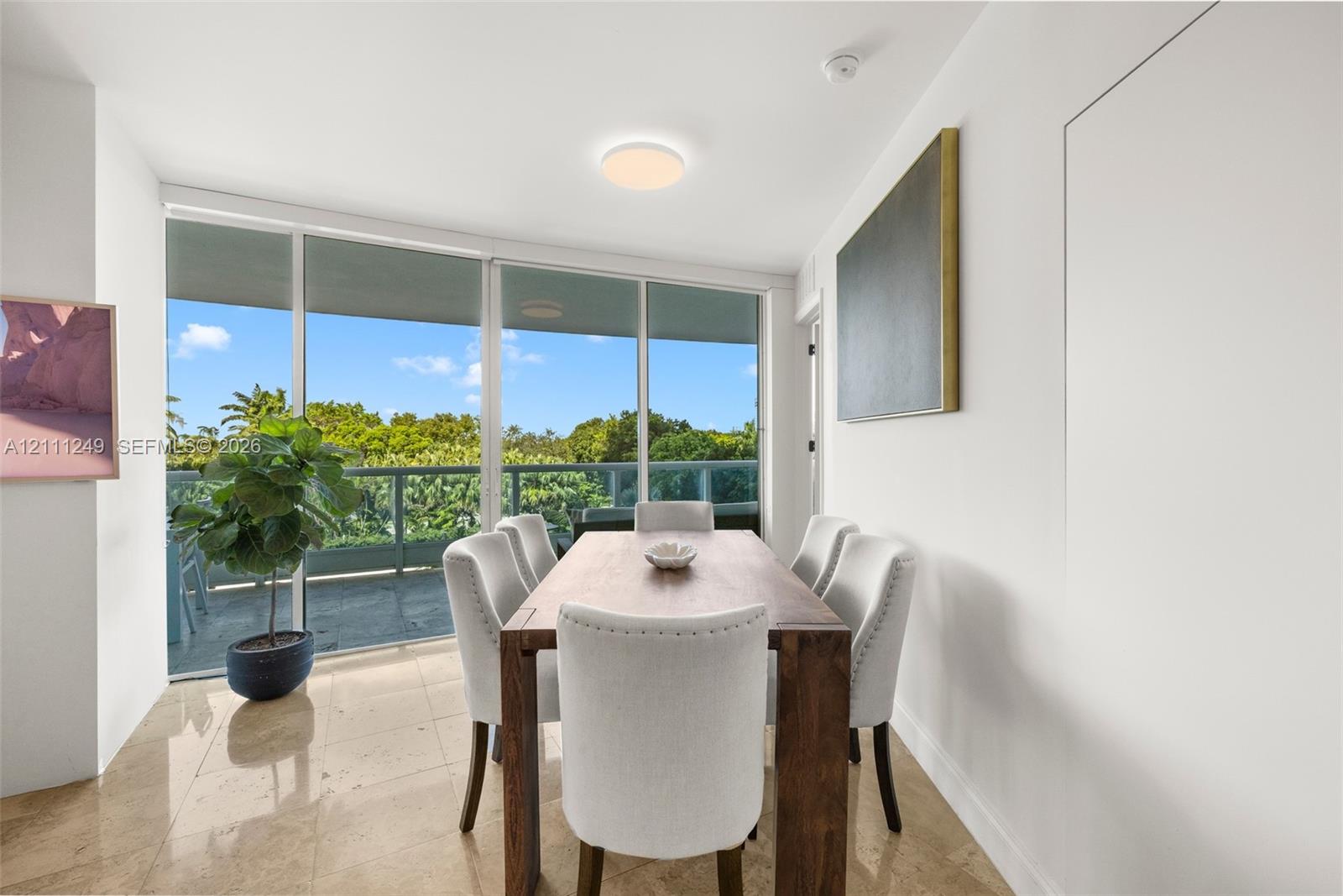 Floor-to-ceiling glass panel windows, polished stone flooring, and access to a balcony with metal railing Floor-to-ceiling glass panel windows, polished stone flooring, and access to a balcony with metal railing