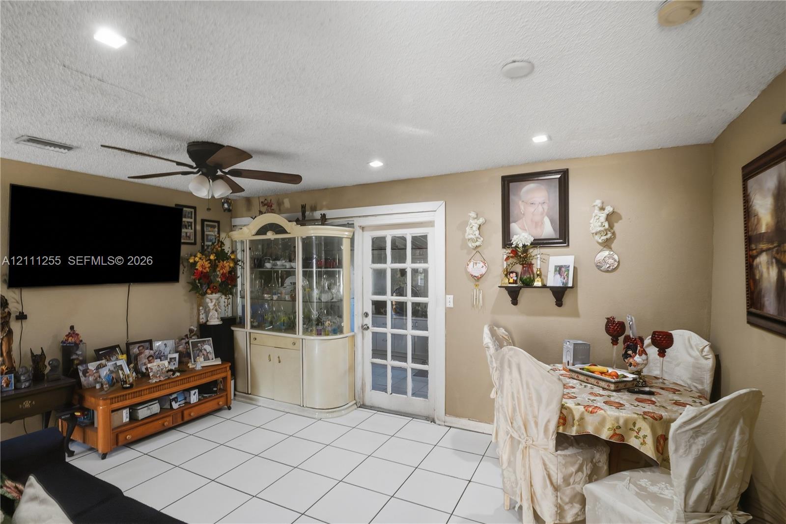 Living space featuring ceramic tile flooring, recessed lighting, ceiling fan, and glass-paned exterior door