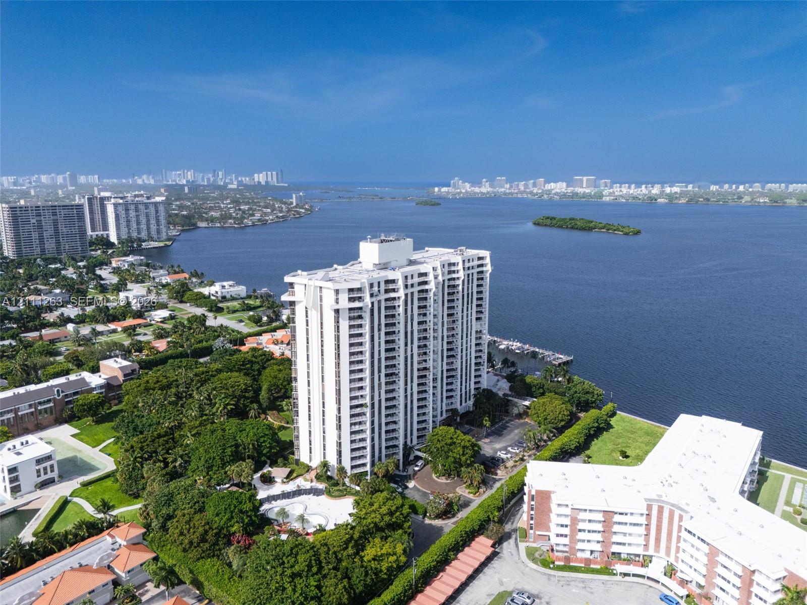 High-rise residential building situated on the waterfront featuring a swimming pool, private boat slips, and extensive perimeter landscaping