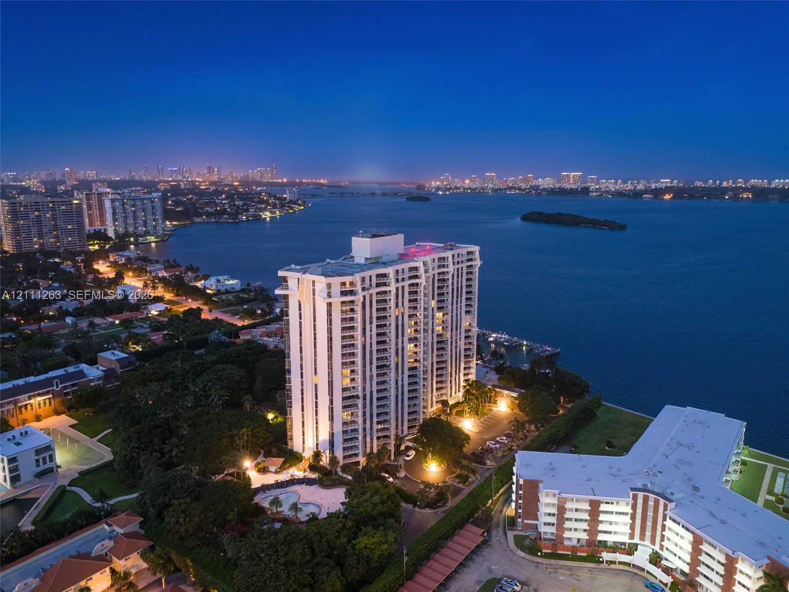 High-rise residential tower featuring a waterfront location, balconies, and an outdoor swimming pool set within landscaped grounds