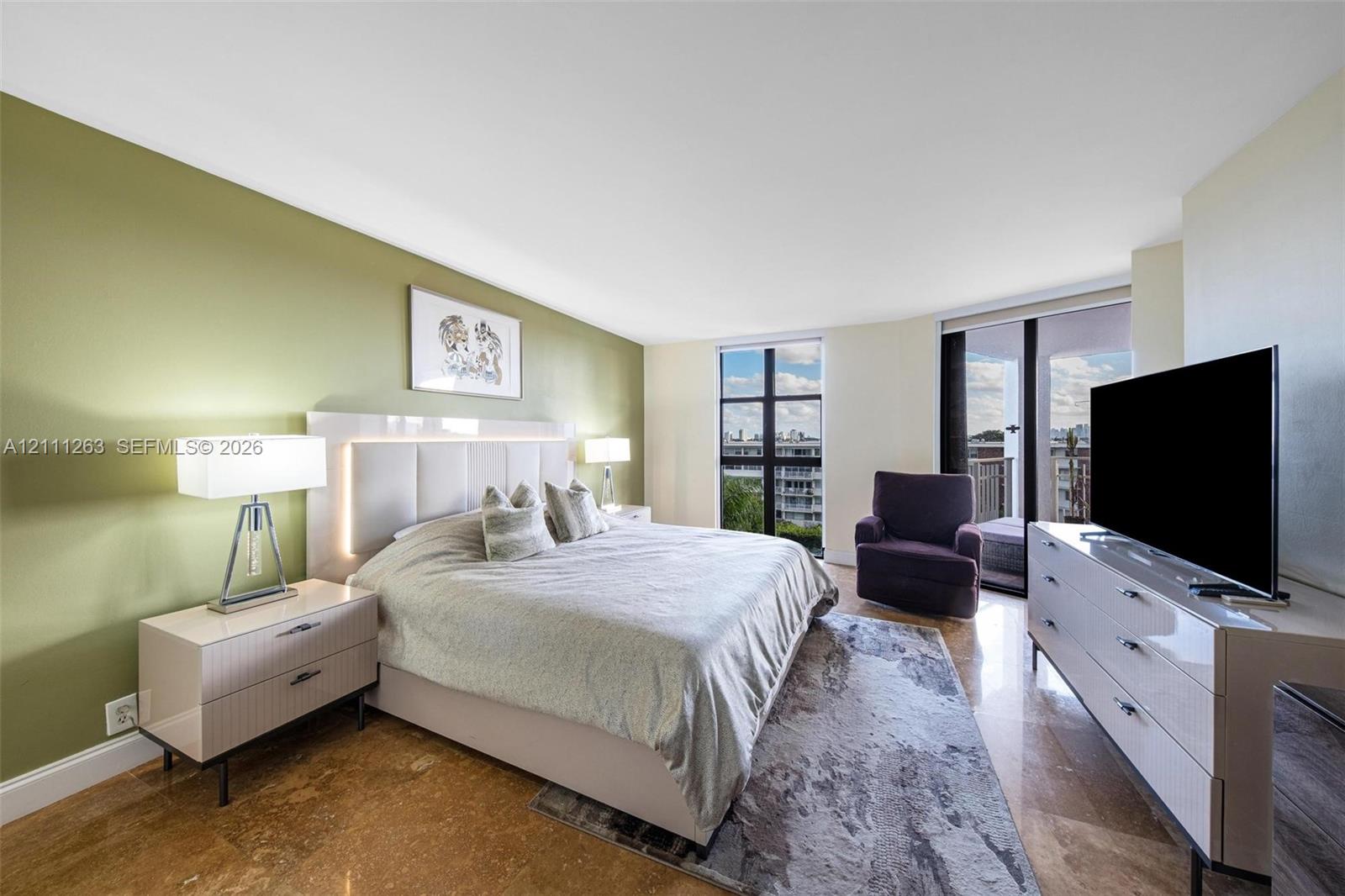 Bedroom featuring polished stone flooring, floor-to-ceiling windows, and access to an exterior balcony
