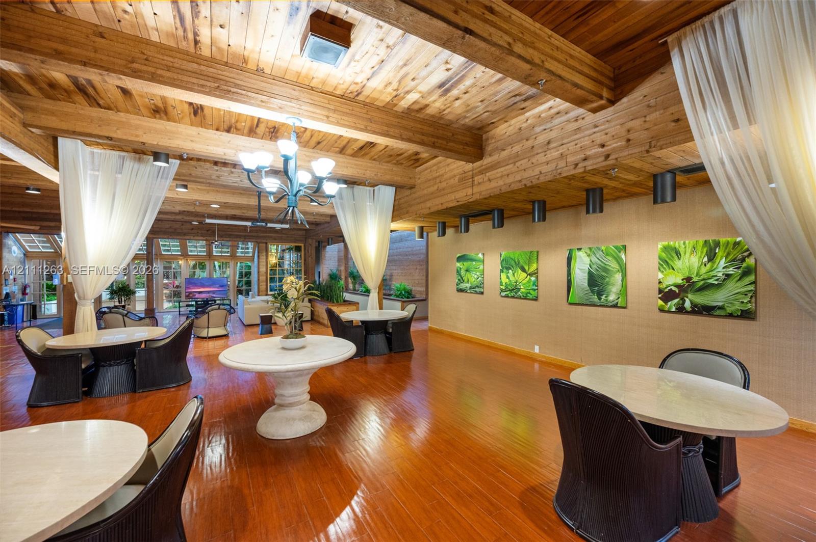 Exposed timber ceiling beams, wood-finish flooring, multi-light chandelier, and recessed lighting