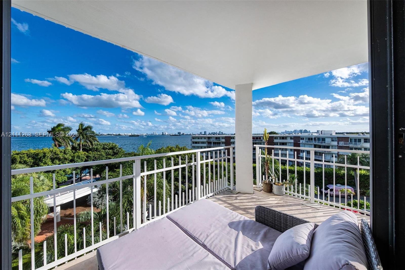 Covered balcony with white metal railings and expansive water scenery