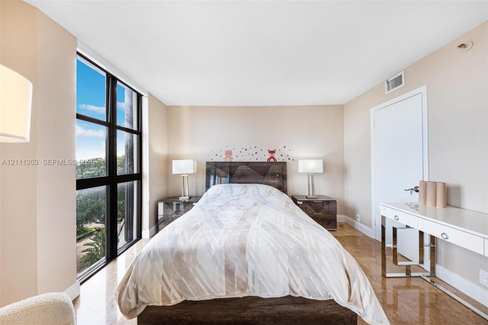 Floor-to-ceiling windows with grid framing, smooth finish ceiling, neutral wall palette, and polished stone-finish flooring