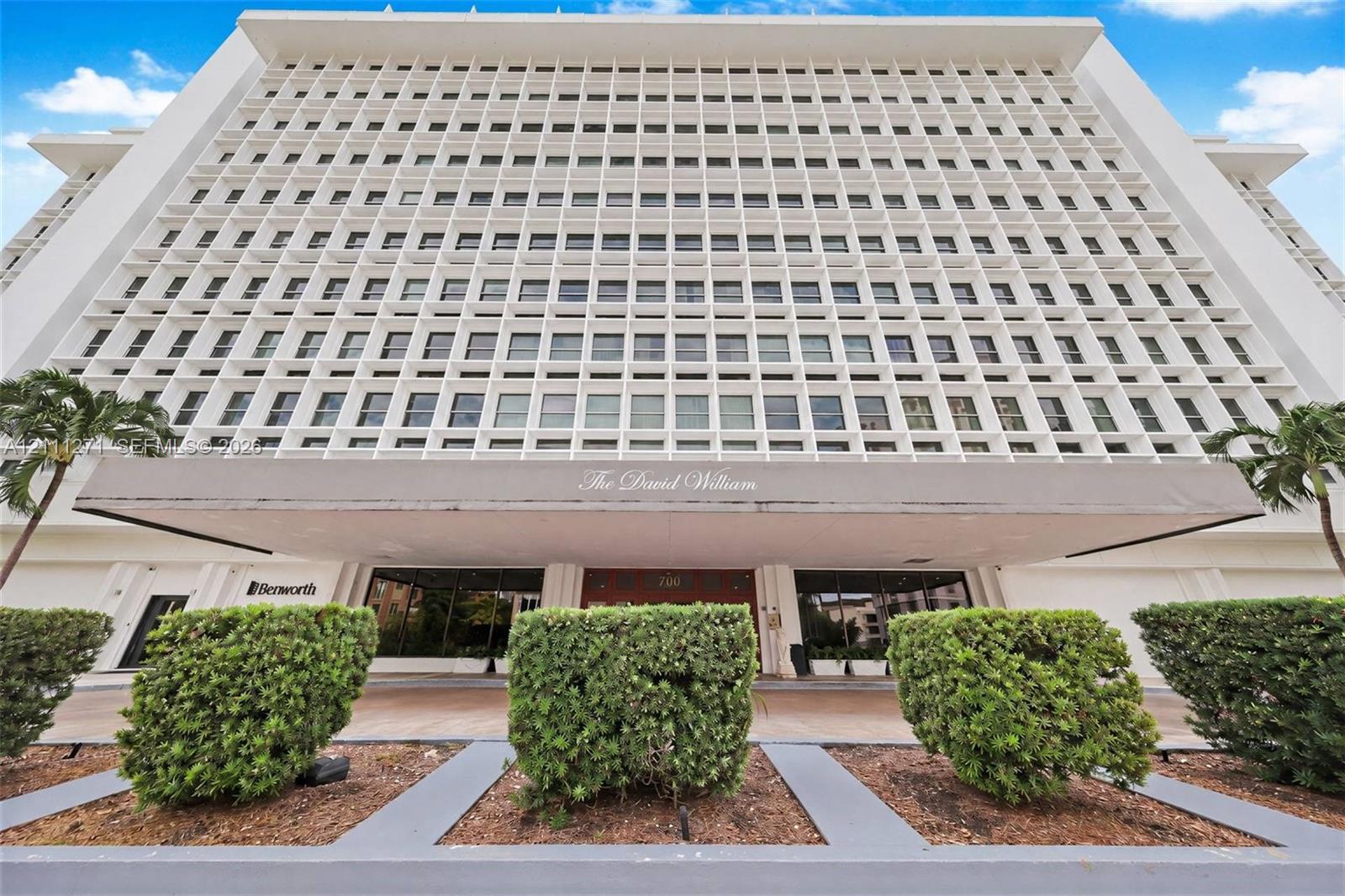Mid-century modern high-rise exterior featuring a distinctive concrete grid faade, cantilevered entrance canopy, and manicured landscaping Mid-century modern high-rise exterior featuring a distinctive concrete grid faade, cantilevered entrance canopy, and manicured landscaping