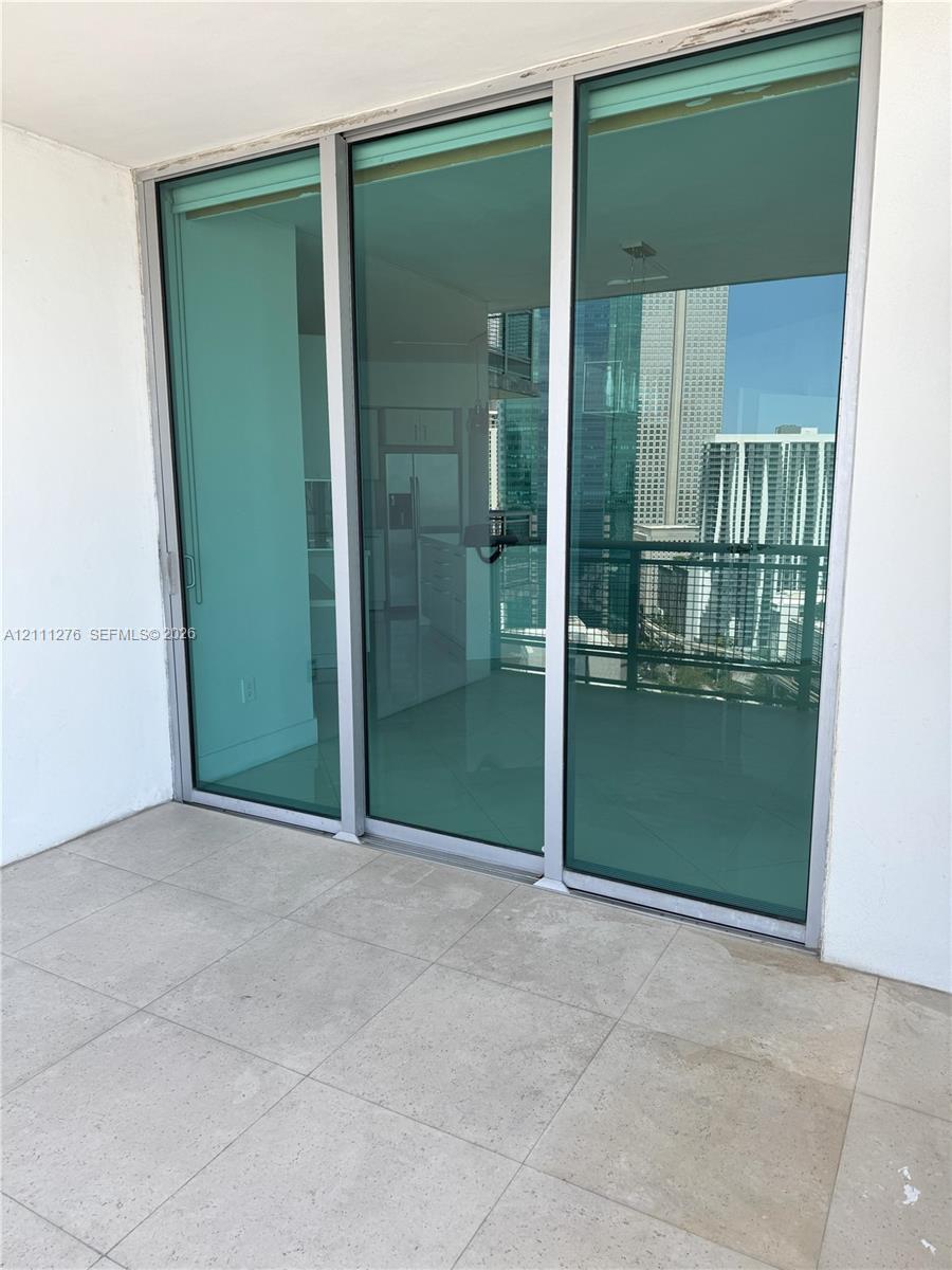 Balcony featuring large-format tile flooring and floor-to-ceiling glass sliding doors with aluminum frames
