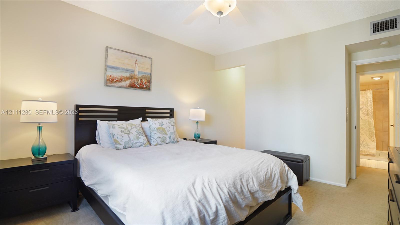 Neutral-toned interior space featuring a ceiling fan with integrated lighting and carpeting