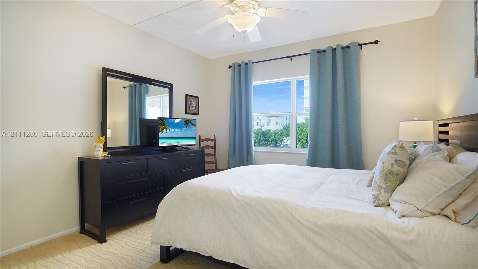 Neutral-toned room featuring a central ceiling fan with an integrated light fixture and a large rectangular window