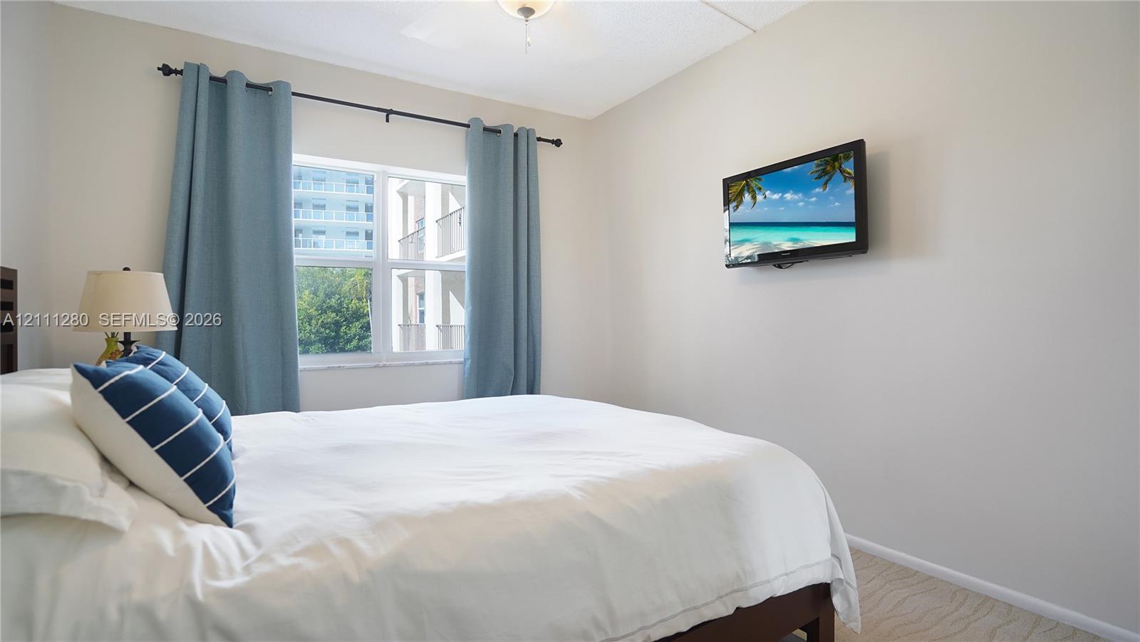 Neutral-toned interior featuring wall-to-wall carpeting, a dual-pane window, and a ceiling-mounted light fixture