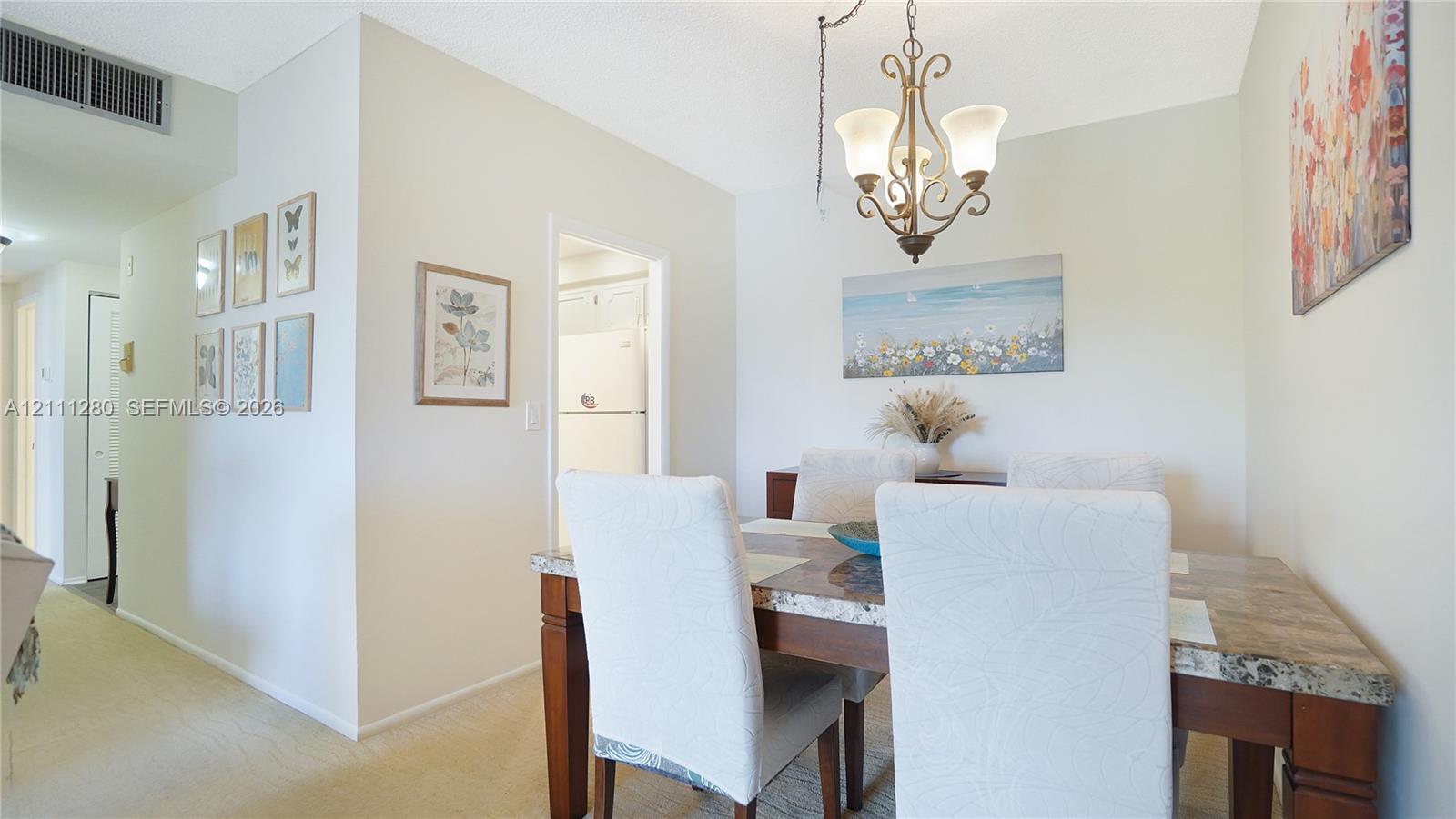 Dining area featuring a decorative metal chandelier and neutral wall tones