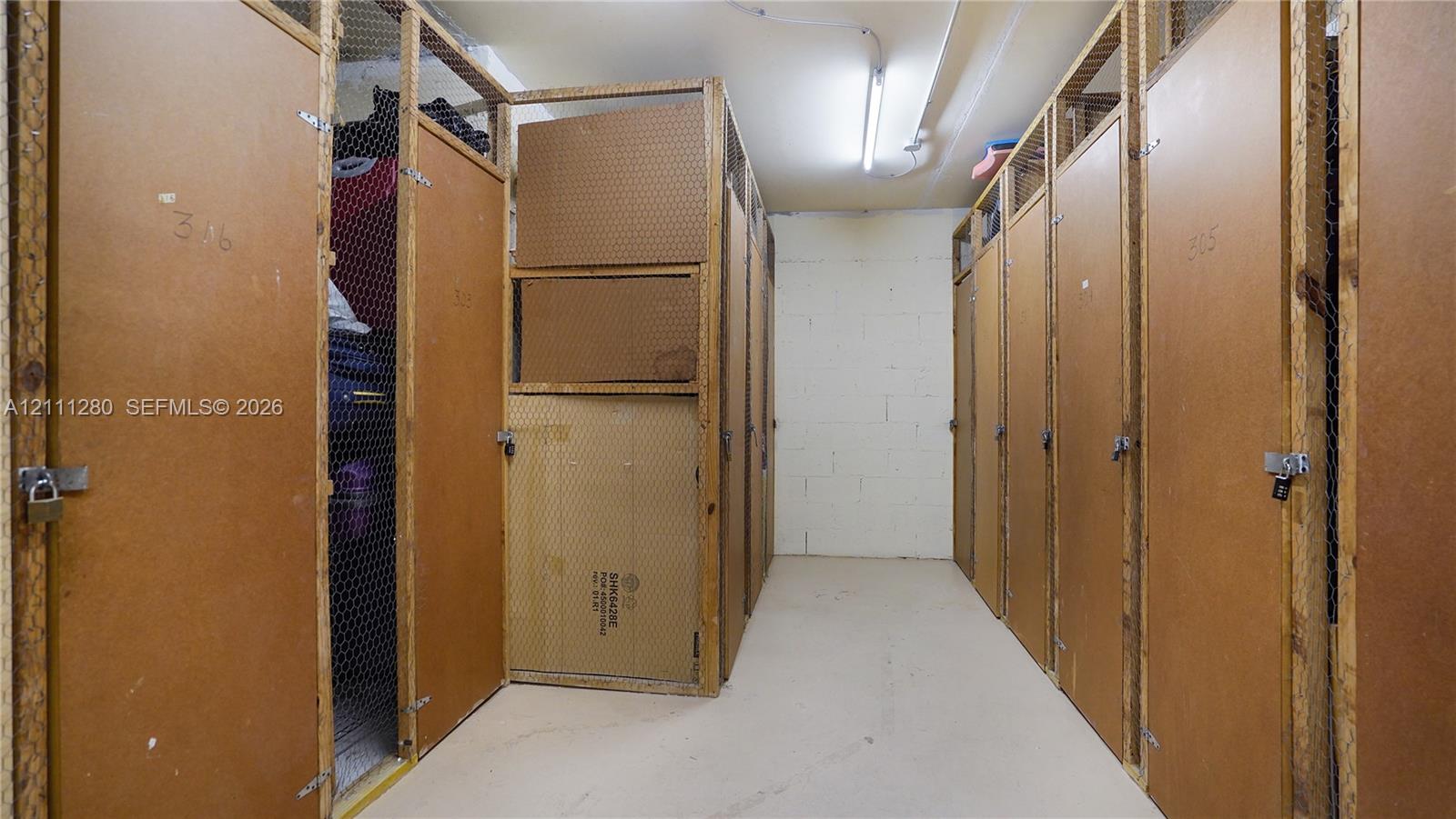 Dedicated storage area featuring enclosed wooden locker units with wire mesh paneling and secure padlock hasps