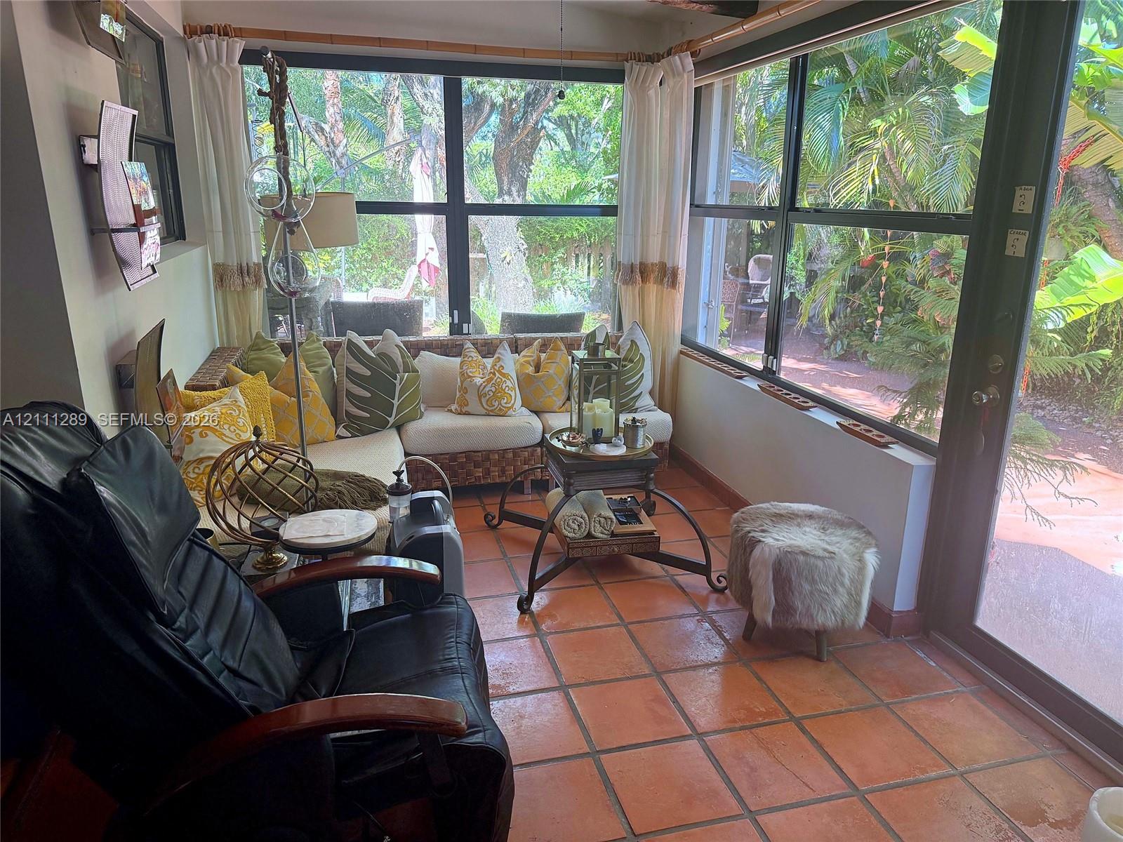 Sunroom featuring ceramic tile flooring, floor-to-ceiling windows, and a glass-paneled door Sunroom featuring ceramic tile flooring, floor-to-ceiling windows, and a glass-paneled door