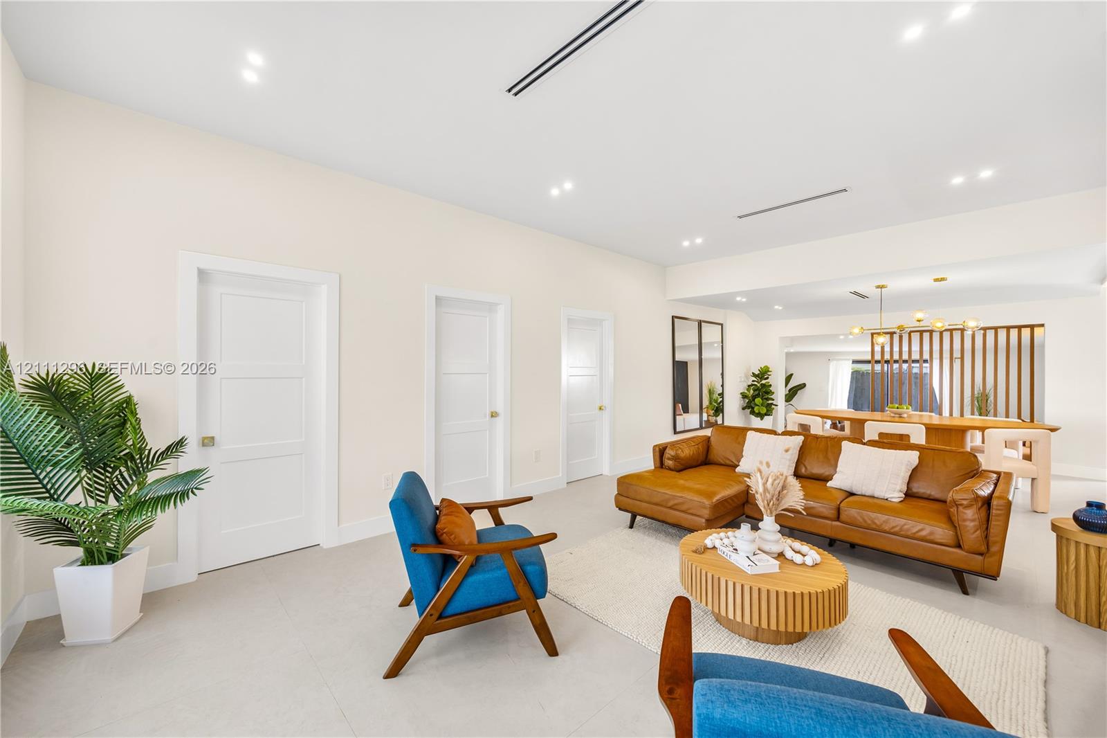 Neutral interior featuring recessed lighting, smooth ceiling finish, three-panel interior doors, light-toned tile flooring, and a decorative vertical slat room divider