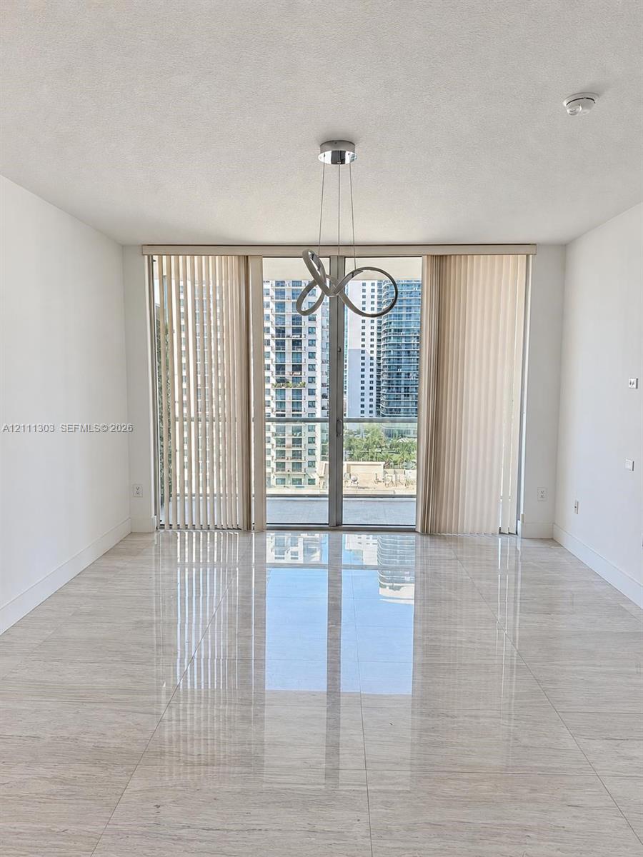 Polished stone-finish flooring, floor-to-ceiling glass sliding doors, private balcony, and a contemporary sculptural pendant light fixture Polished stone-finish flooring, floor-to-ceiling glass sliding doors, private balcony, and a contemporary sculptural pendant light fixture