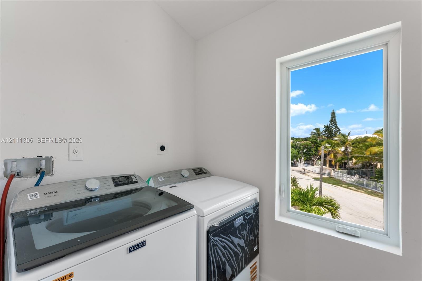 Laundry room featuring a vaulted ceiling and a window providing exterior natural light