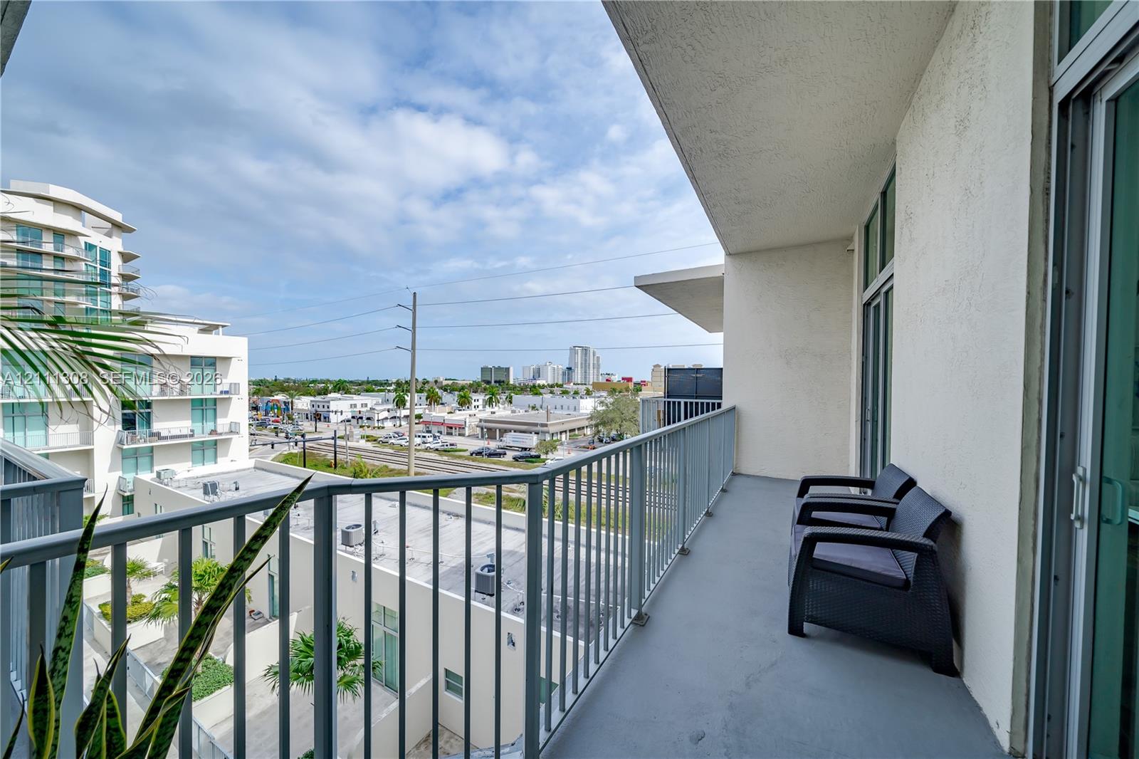 Covered balcony featuring concrete flooring and a vertical metal railing Covered balcony featuring concrete flooring and a vertical metal railing