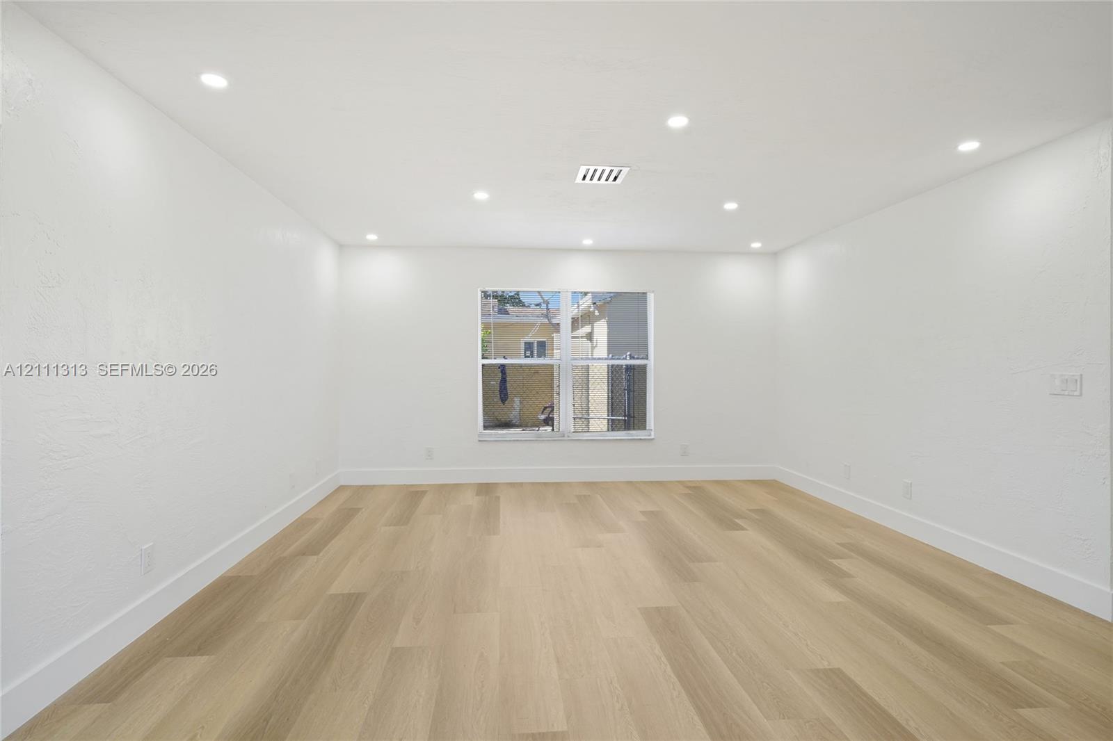 Interior space featuring wood-finish flooring, recessed lighting, and a single-pane window