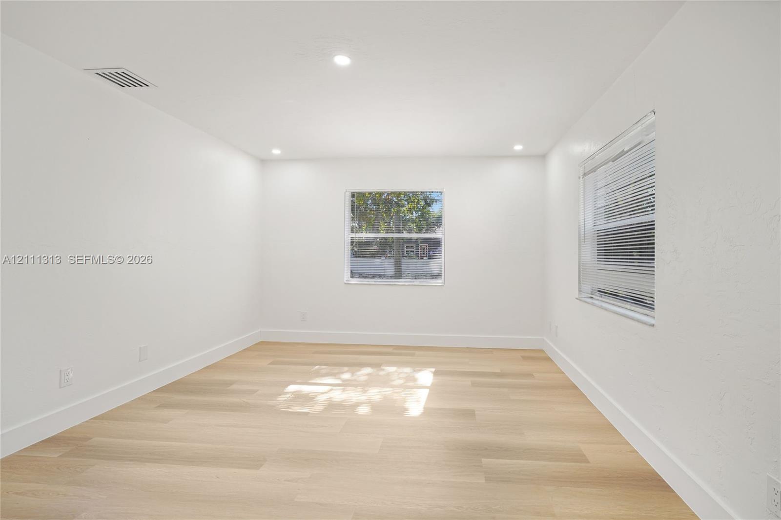 Interior space featuring neutral wall paint, wood-finish flooring, recessed lighting, and dual windows