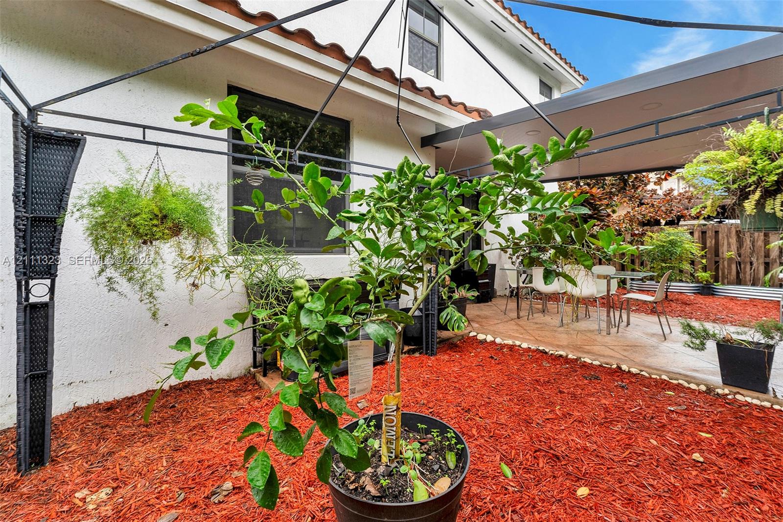 Patio space featuring a covered lanai, concrete flooring, stucco exterior wall, and wood-fence perimeter