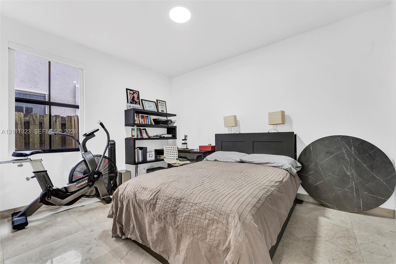 Neutral interior space featuring polished tile flooring, a recessed ceiling light, and a window with a black frame