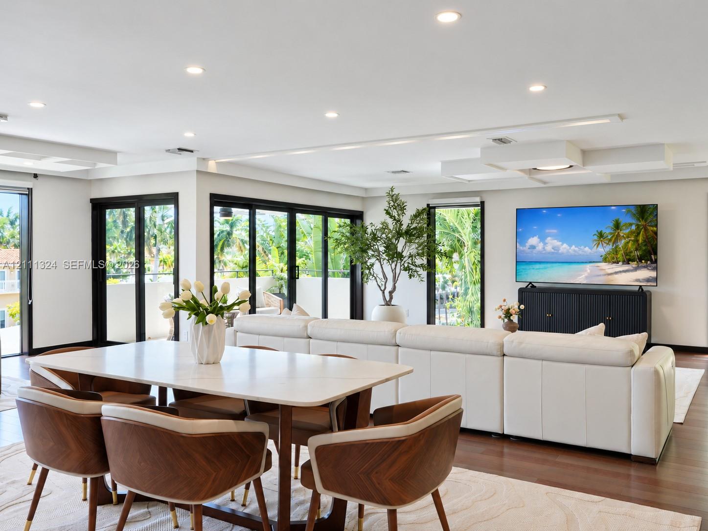 Open-concept living space featuring wood-finish flooring, recessed lighting, and expansive glass sliding doors