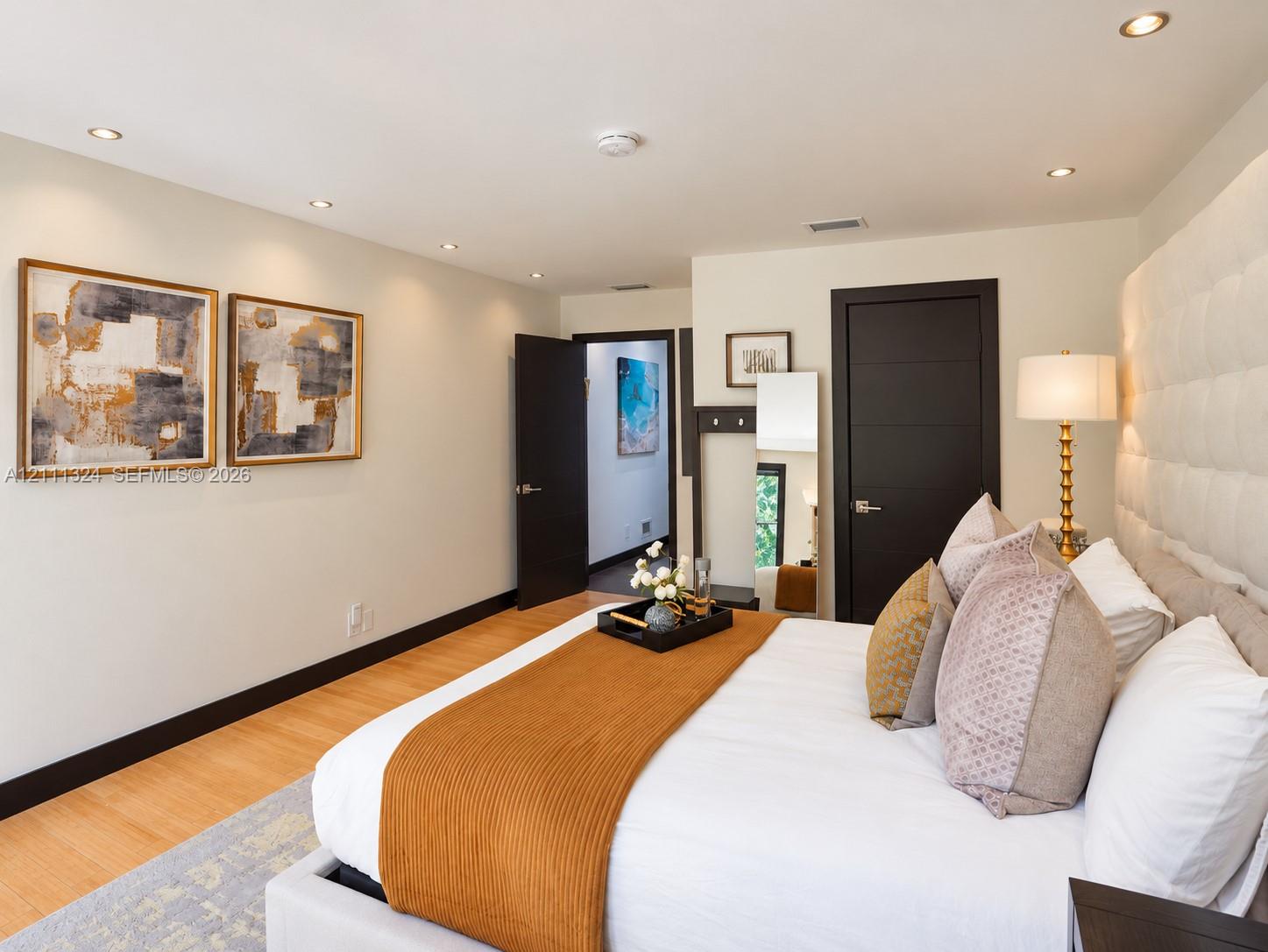 Neutral wall color, wood-finish flooring, recessed lighting, and solid-core interior doors with metallic hardware