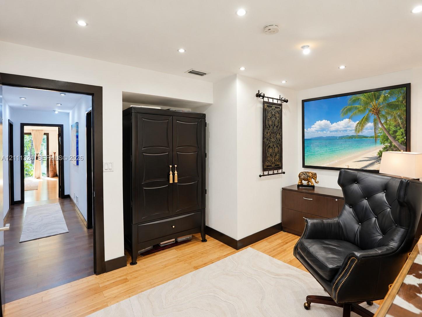 Interior space featuring wood-finish flooring, recessed ceiling lighting, and contrasting dark-finished door trim