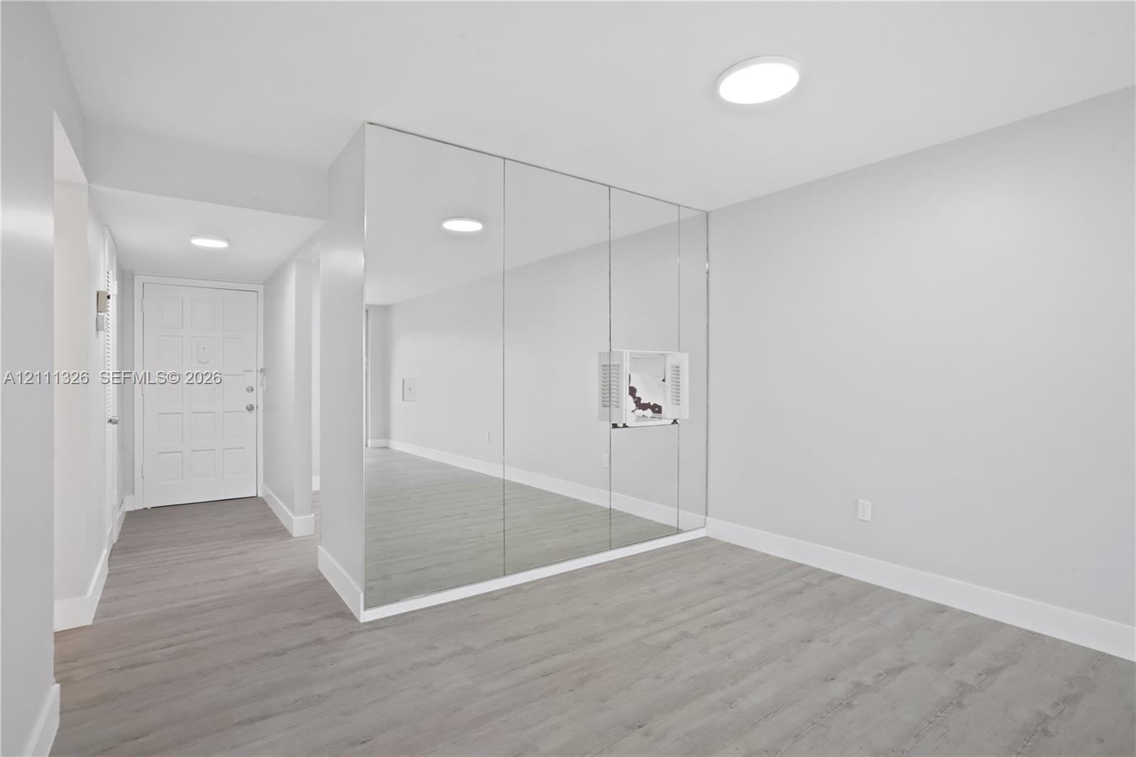 View of dining area from living room with entrance in the distance.