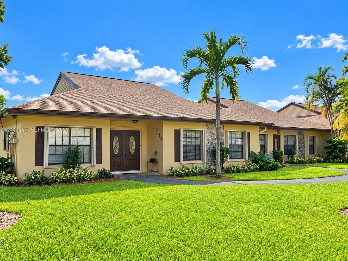 Single-story exterior featuring a hip roof, dual-entry doors with decorative glass inserts, stone masonry accents, and multi-pane windows with shutters Single-story exterior featuring a hip roof, dual-entry doors with decorative glass inserts, stone masonry accents, and multi-pane windows with shutters
