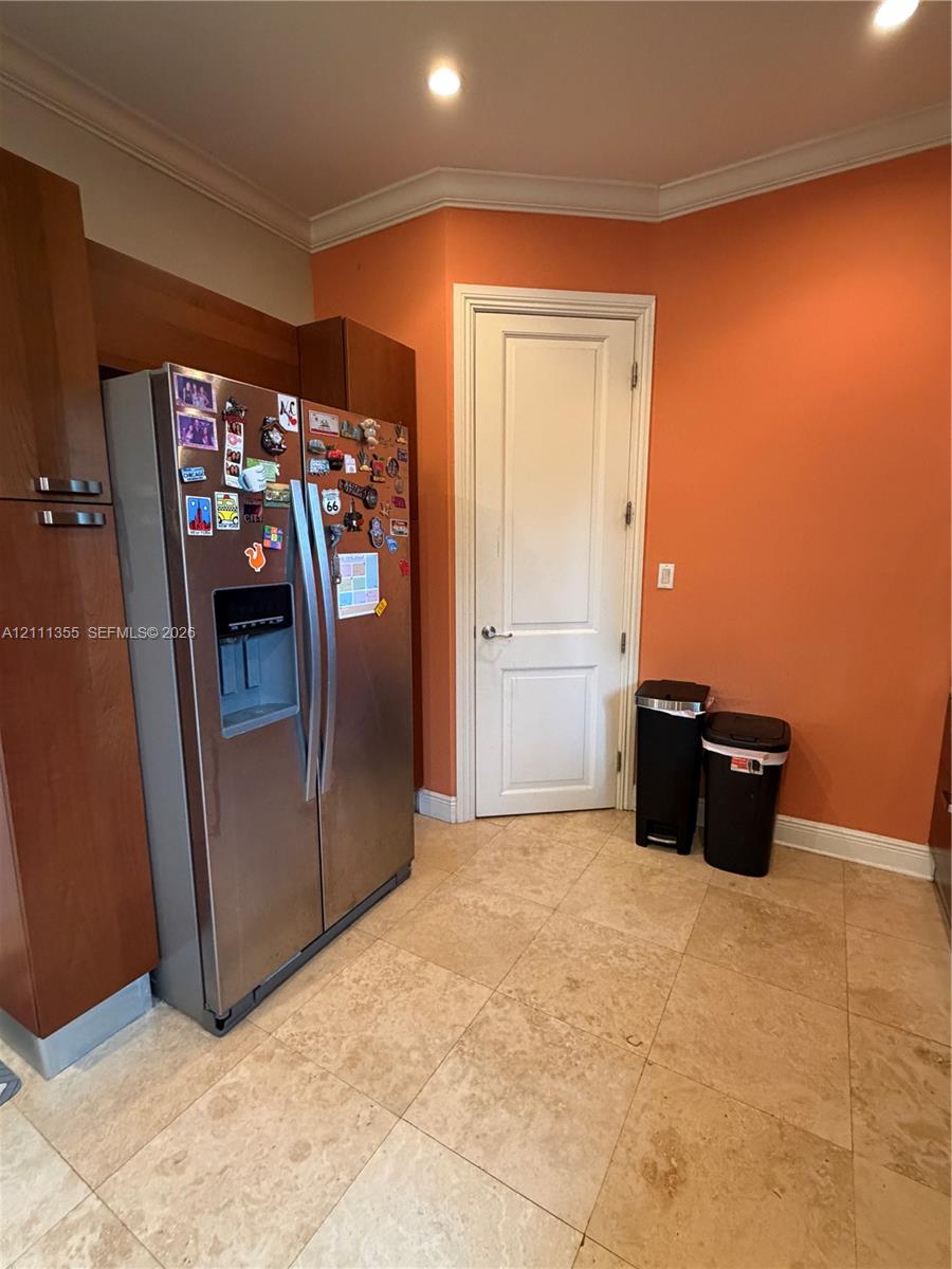 Stone-tile flooring, recessed ceiling lighting, and built-in wood-finish cabinetry