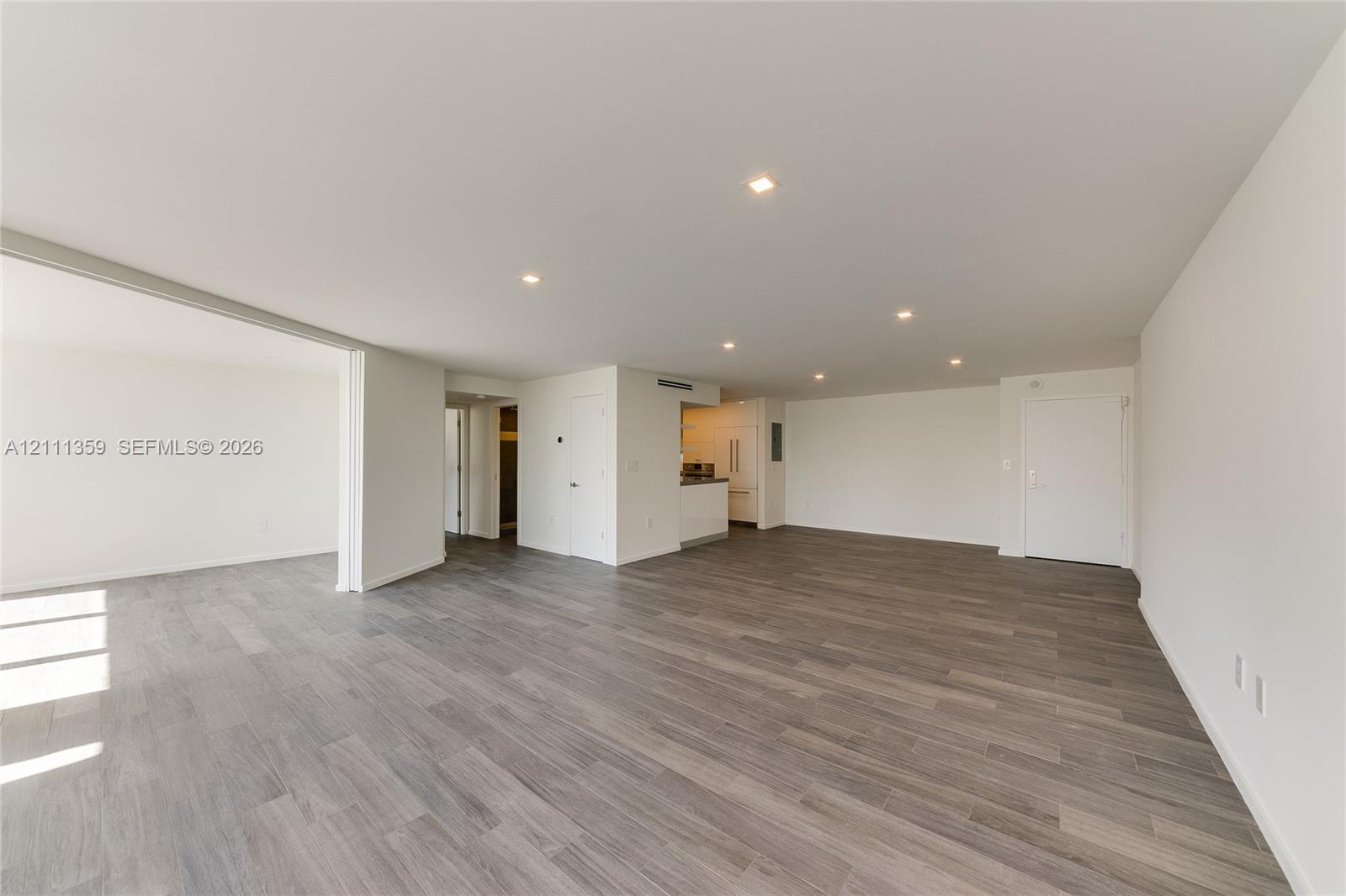 Open-concept interior featuring wood-finish flooring, recessed lighting, and neutral wall tones