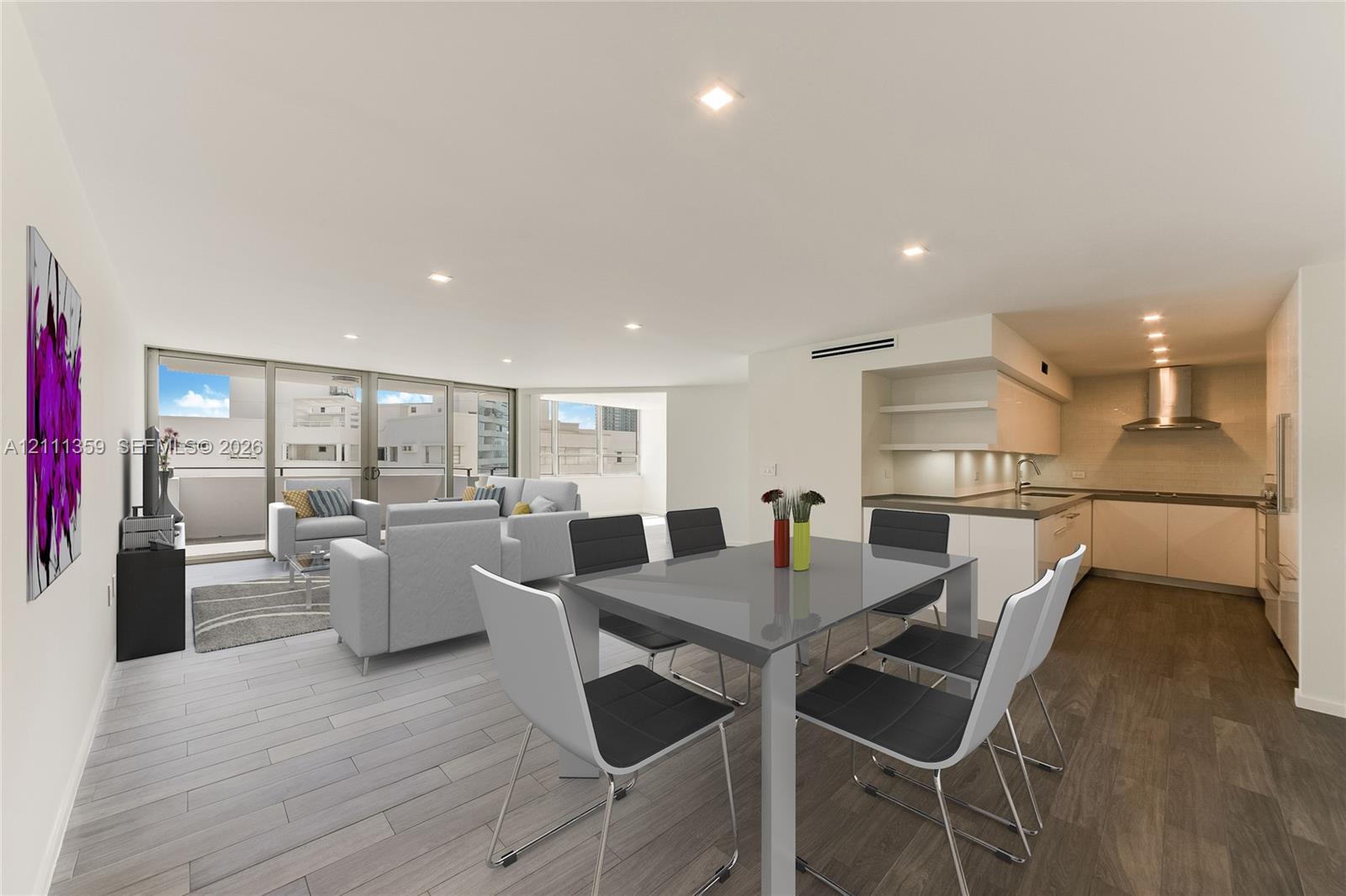 Open-concept living space featuring wood-finish flooring, recessed lighting, floor-to-ceiling glass sliding doors, and a kitchen equipped with flat-panel cabinetry, a stainless steel range hood, and solid-surface countertops
