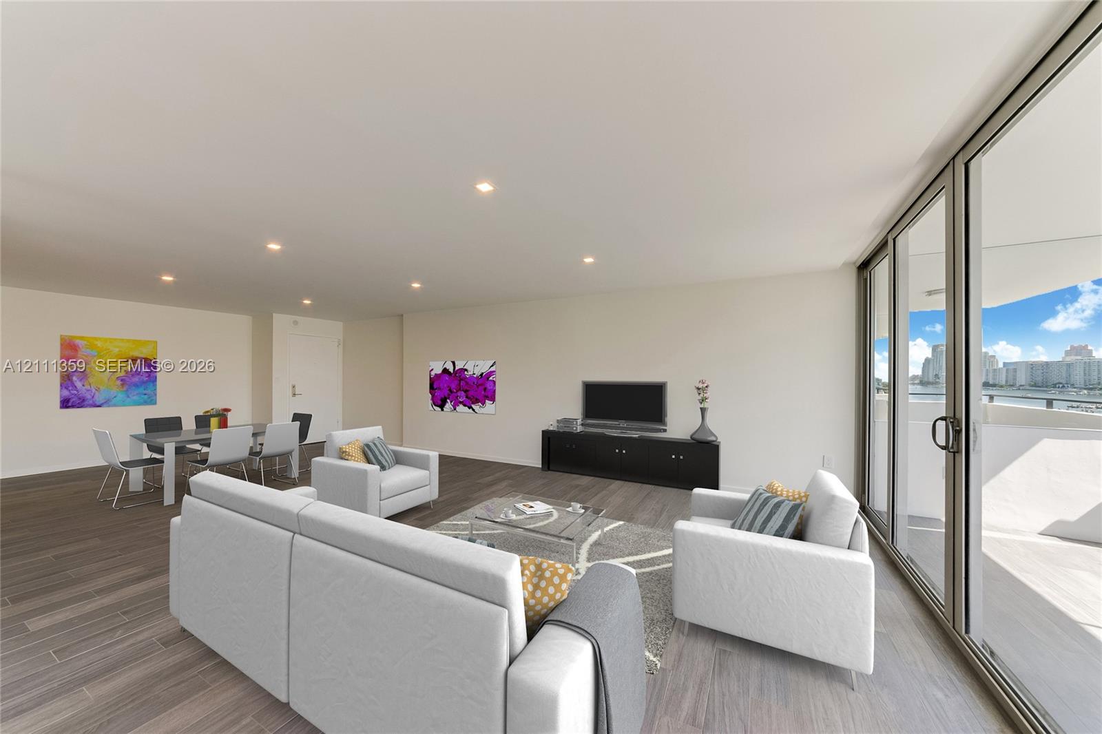 Open-concept floor plan featuring wood-finish flooring, recessed lighting, and expansive floor-to-ceiling sliding glass doors opening to a balcony