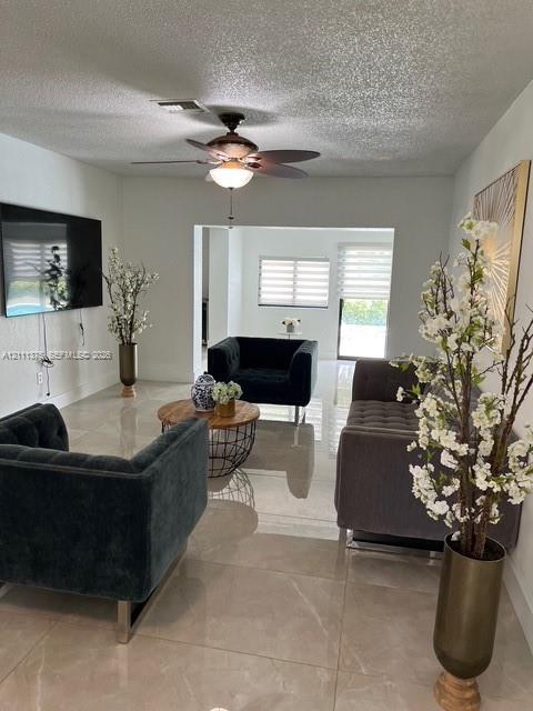 Polished tile flooring, neutral wall tones, multi-speed ceiling fan with integrated lighting, and horizontal window shades