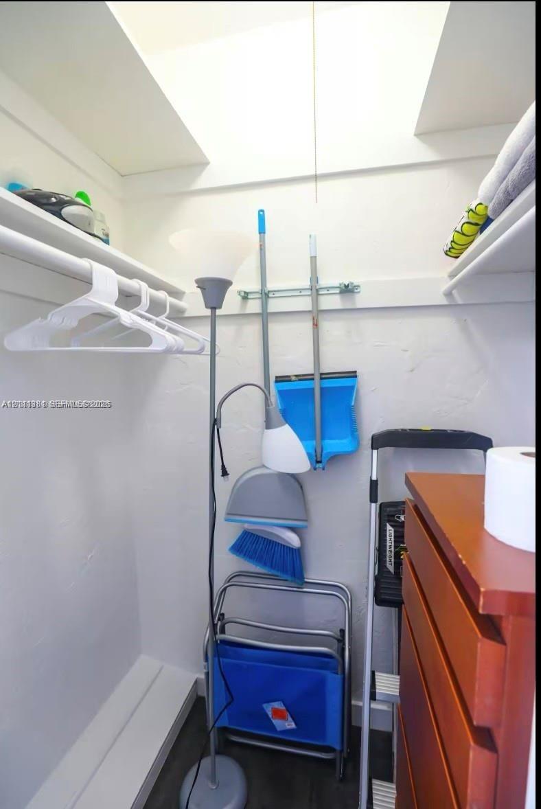 Storage space featuring dual upper shelving and a clothes hanging rod