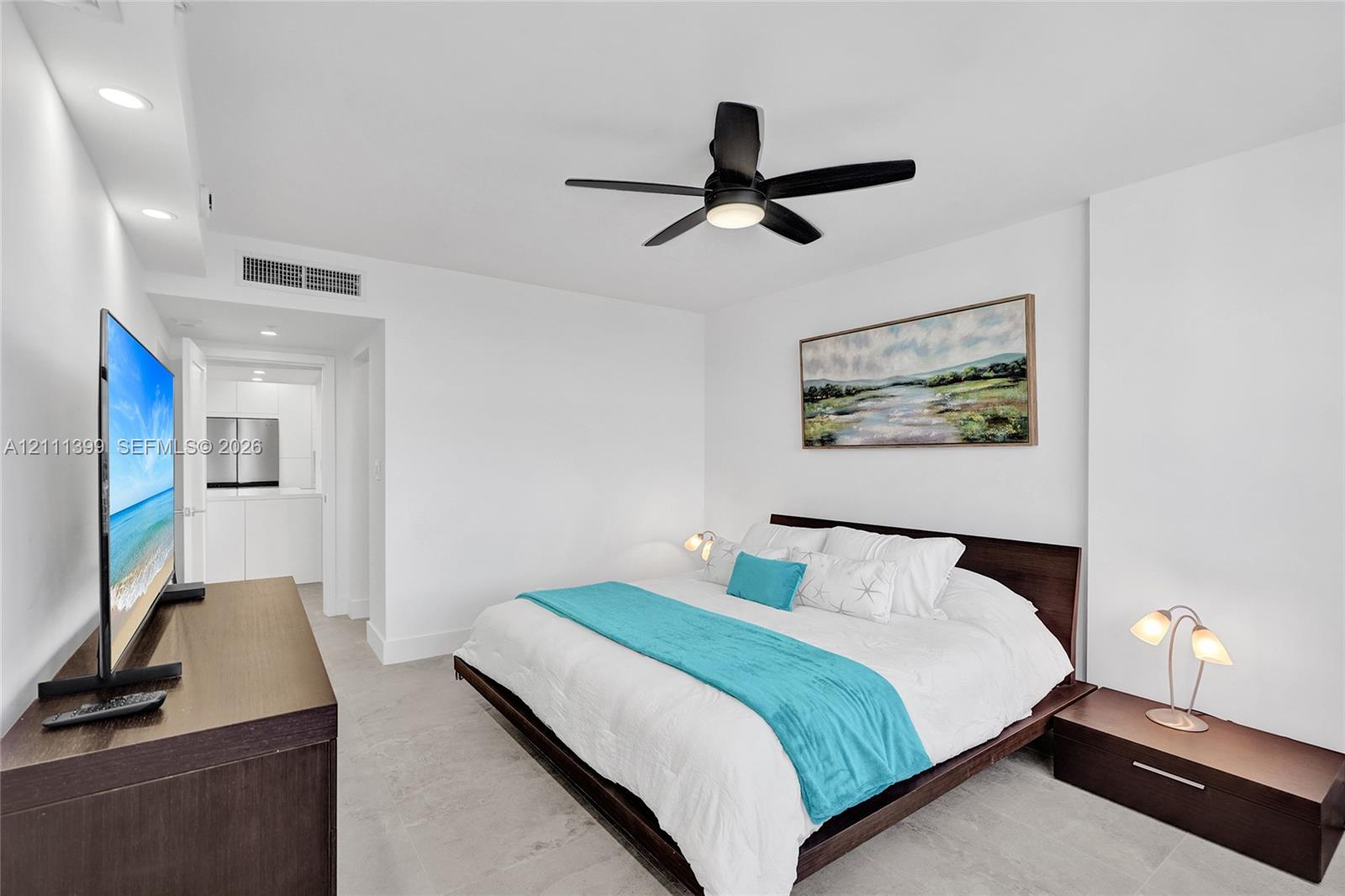 Neutral interior featuring light-toned flooring, recessed ceiling lighting, and a modern black multi-blade ceiling fan
