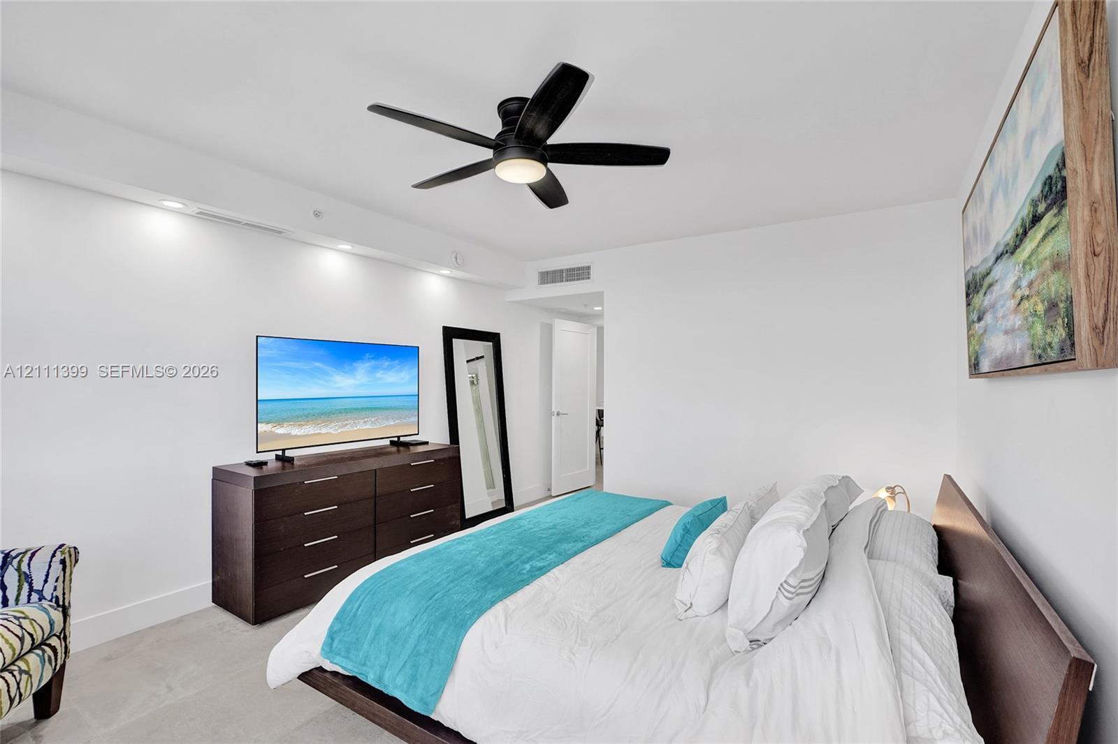 Recessed ceiling lighting, matte black five-blade ceiling fan, and large-format neutral tile flooring
