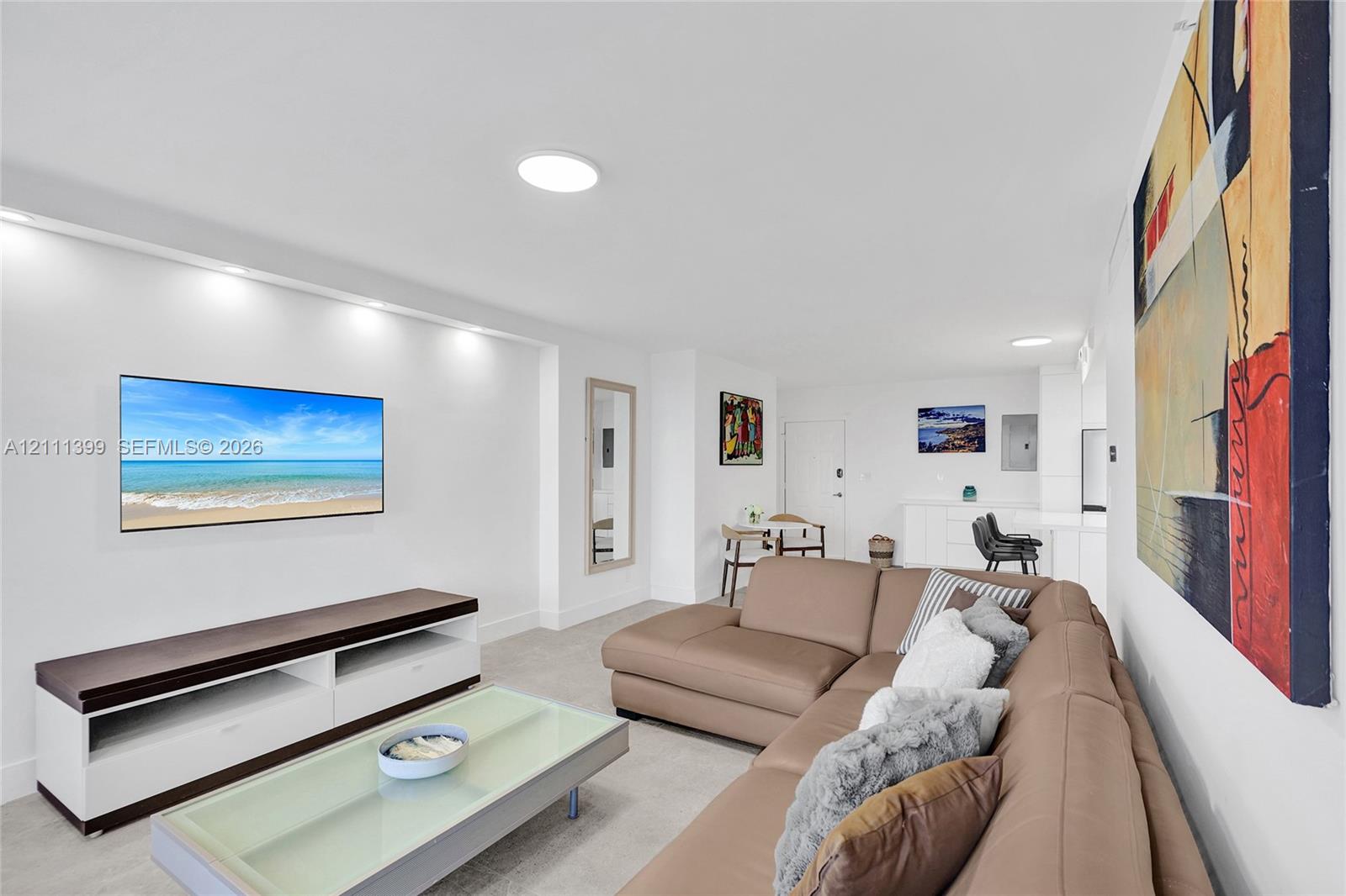 Living area featuring recessed wall shelving with integrated lighting and flush-mount ceiling lighting
